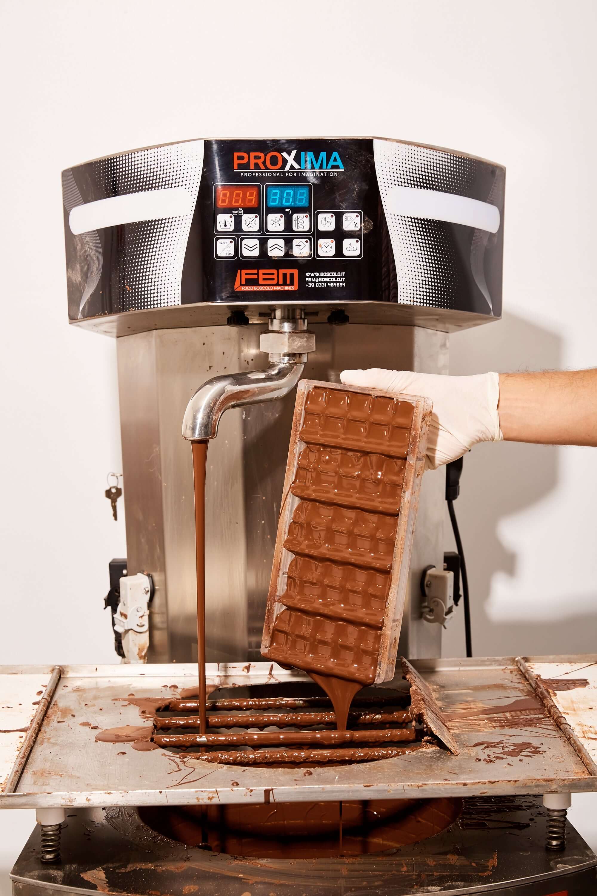 Chocolate being poured from a machine into bars, showcasing corporate gifting and high-quality treats.