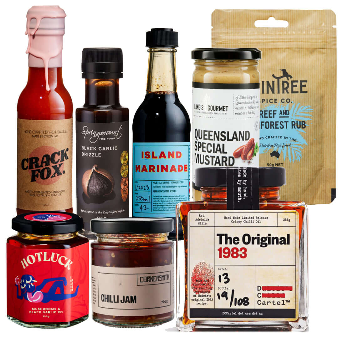 Assorted gourmet BBQ sauces and condiments including hot sauces, marinades, and mustards for holiday gifting.