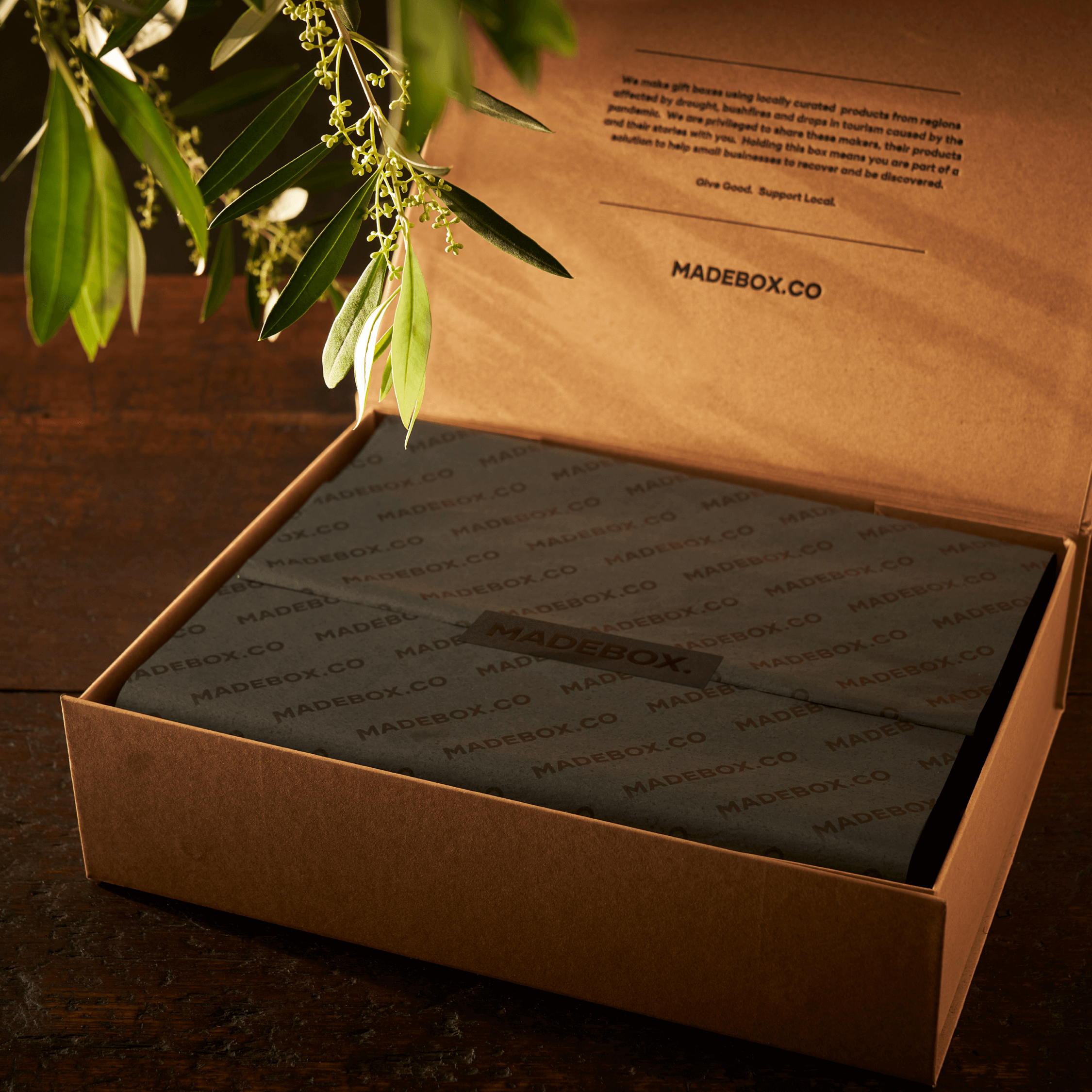 Gift box from MADEBOX.co, featuring eco-friendly packaging on a rustic wooden surface.